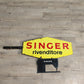 76009 Insegna vintage Singer con piccola macchina da cucire nera