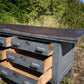Bancone industriale vintage in legno con piano rivestito in ferro con 12 cassetti