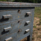 Bancone industriale vintage in legno con piano rivestito in ferro con 12 cassetti
