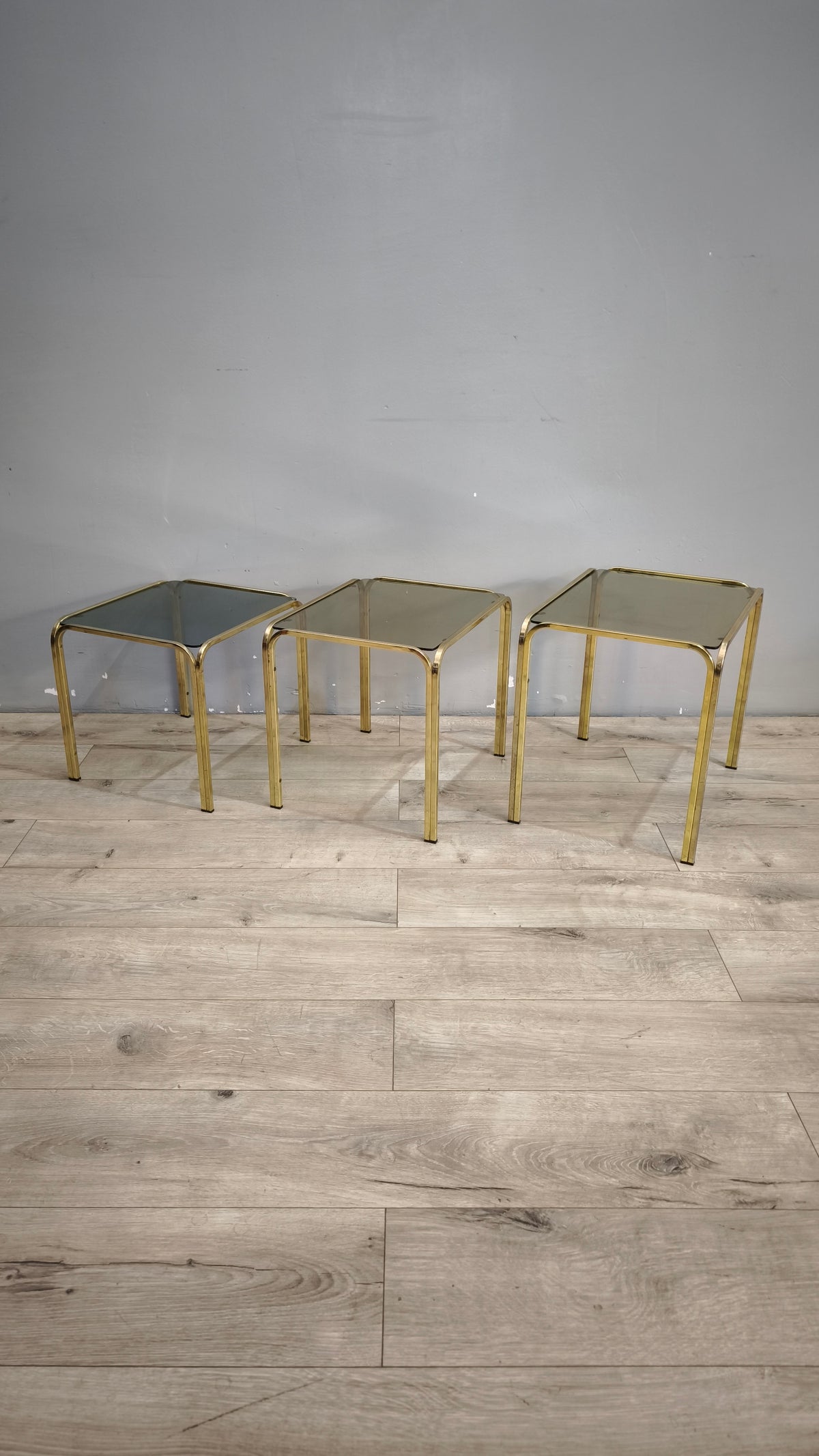 93175 Trittico tavolini da salotto in metallo dorato e piano in vetro